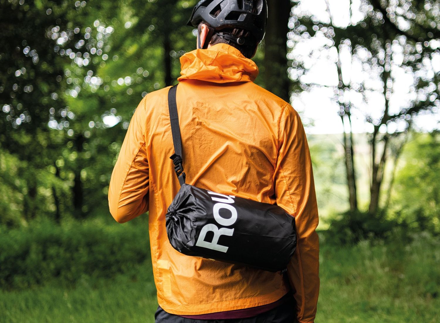 Rider carrying the packed RoughSac over the shoulder